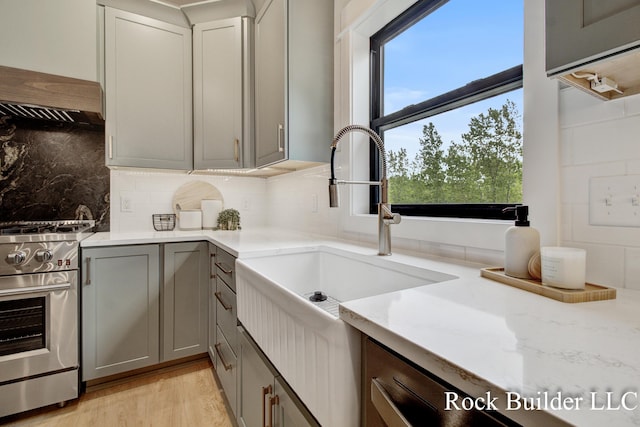 7134 Sugar Maple Dr, Hudsonville, MI 49426 - kitchen featuring stainless steel range, a sink, gray cabinets, tasteful backsplash, and light wood-style floors