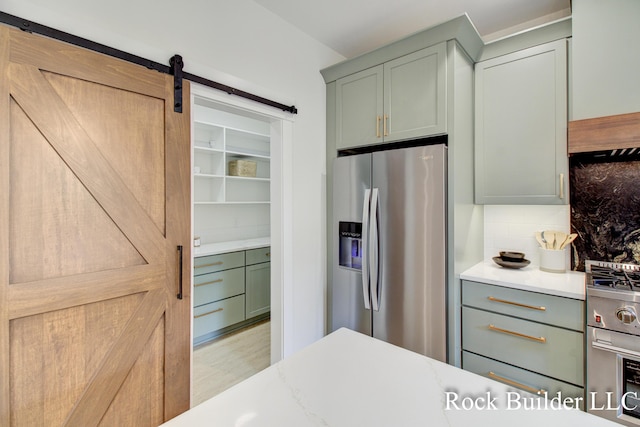 7134 Sugar Maple Dr, Hudsonville, MI 49426 - kitchen with stainless steel refrigerator with ice dispenser, a barn door, tasteful backsplash, and green cabinets