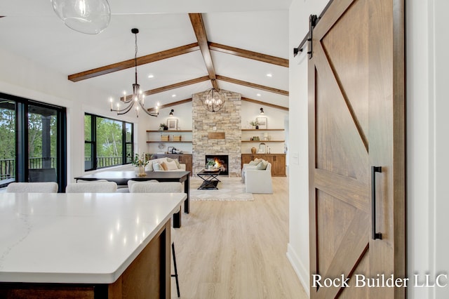 7134 Sugar Maple Dr, Hudsonville, MI 49426 - kitchen featuring light wood-style floors, recessed lighting, a chandelier, hanging light fixtures, and a fireplace