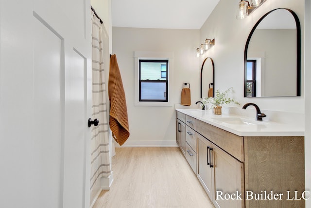 7134 Sugar Maple Dr, Hudsonville, MI 49426 - full bathroom with double vanity, wood finished floors, and baseboards