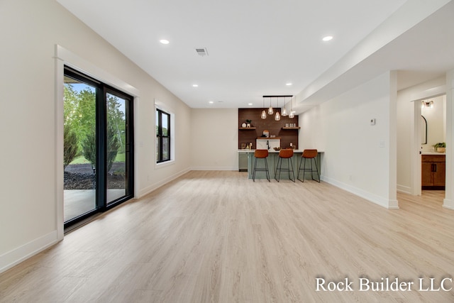 7134 Sugar Maple Dr, Hudsonville, MI 49426 - unfurnished living room with wet bar, light wood finished floors, recessed lighting, and baseboards