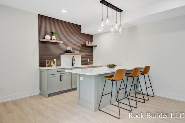7134 Sugar Maple Dr, Hudsonville, MI 49426 - kitchen with open shelves, a breakfast bar, light wood-style flooring, gray cabinetry, and recessed lighting