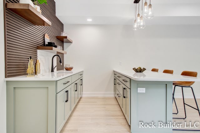 7134 Sugar Maple Dr, Hudsonville, MI 49426 - kitchen with open shelves, a breakfast bar, a peninsula, light wood-style floors, and baseboards