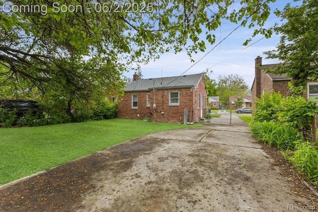 18697 Sunderland Rd, Detroit, MI 48219 - back of house with driveway, a gate, brick siding, and a chimney