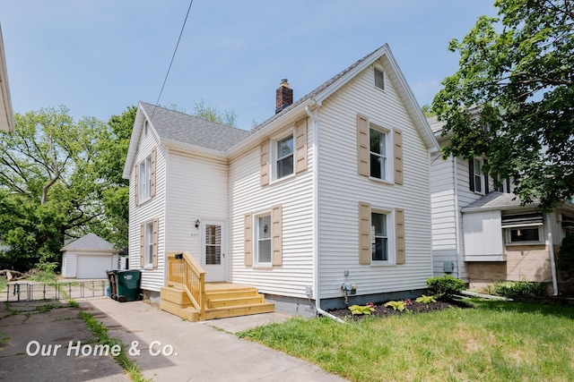 337 N Fairview Ave, Lansing, MI 48912 - view of front of house with a chimney, an outdoor structure, and a detached garage