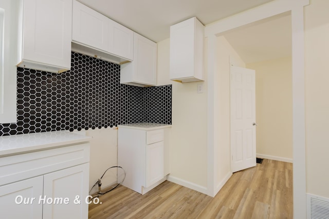 337 N Fairview Ave, Lansing, MI 48912 - kitchen featuring white cabinets, light wood-style flooring, decorative backsplash, and light countertops