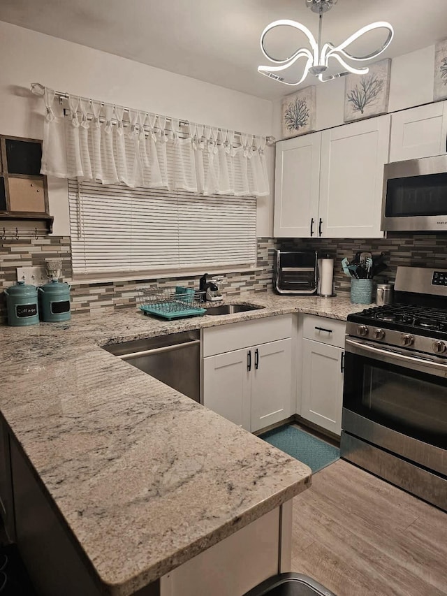 3062 Roundtree Blvd, Ypsilanti, MI 48197 - kitchen with appliances with stainless steel finishes, white cabinets, and backsplash