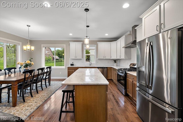 6231 Leighland Dr, Grand Blanc, MI 48439 - kitchen with appliances with stainless steel finishes, a sink, wall chimney range hood, crown molding, and a kitchen island