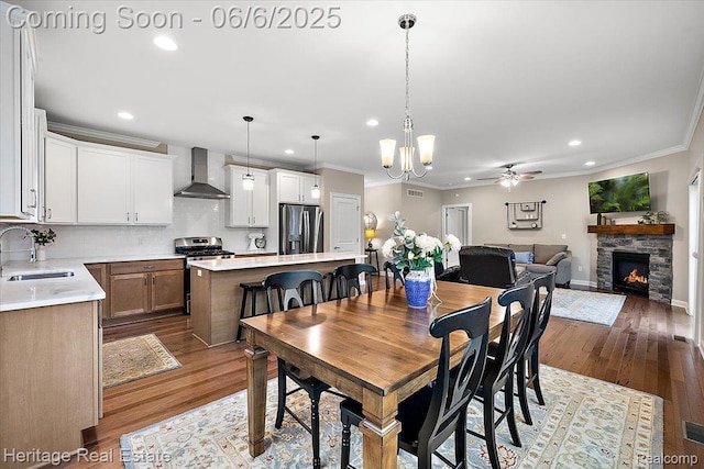 6231 Leighland Dr, Grand Blanc, MI 48439 - dining area with a ceiling fan, recessed lighting, ornamental molding, a fireplace, and wood finished floors