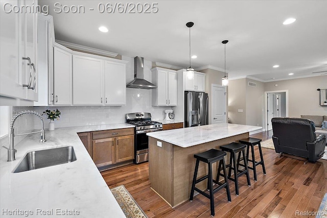 6231 Leighland Dr, Grand Blanc, MI 48439 - kitchen with wall chimney range hood, appliances with stainless steel finishes, a sink, crown molding, and open floor plan