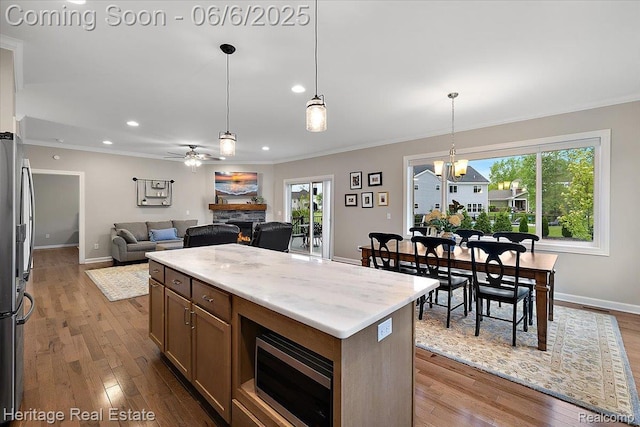 6231 Leighland Dr, Grand Blanc, MI 48439 - kitchen with stainless steel appliances, ornamental molding, a fireplace, baseboards, and plenty of natural light