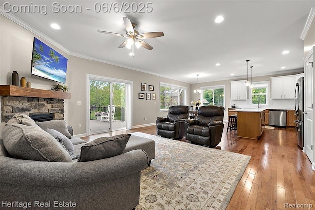 6231 Leighland Dr, Grand Blanc, MI 48439 - living area featuring ornamental molding, a ceiling fan, a stone fireplace, recessed lighting, and hardwood / wood-style flooring