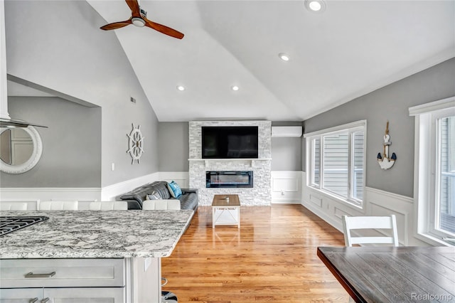 533 Bellevue Ave, Lake Orion, MI 48362 - living room featuring a ceiling fan, a wainscoted wall, light wood-style flooring, a stone fireplace, and recessed lighting