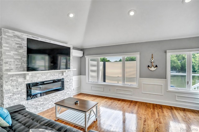 533 Bellevue Ave, Lake Orion, MI 48362 - living area with wainscoting, healthy amount of natural light, lofted ceiling, a stone fireplace, and wood finished floors