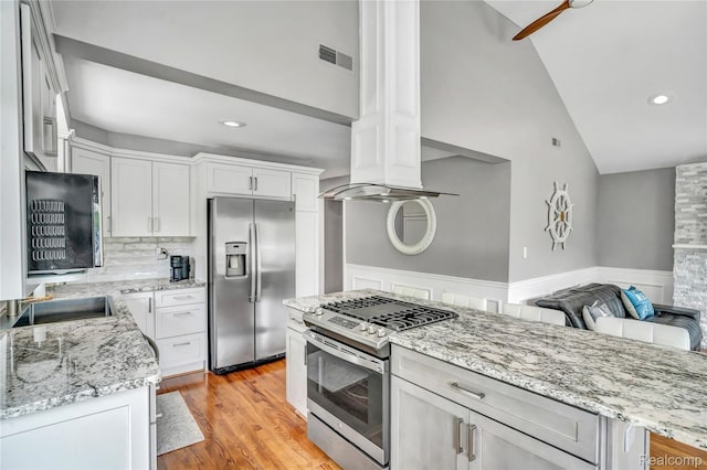 533 Bellevue Ave, Lake Orion, MI 48362 - kitchen with stainless steel appliances, light stone counters, ornate columns, white cabinetry, and light wood finished floors