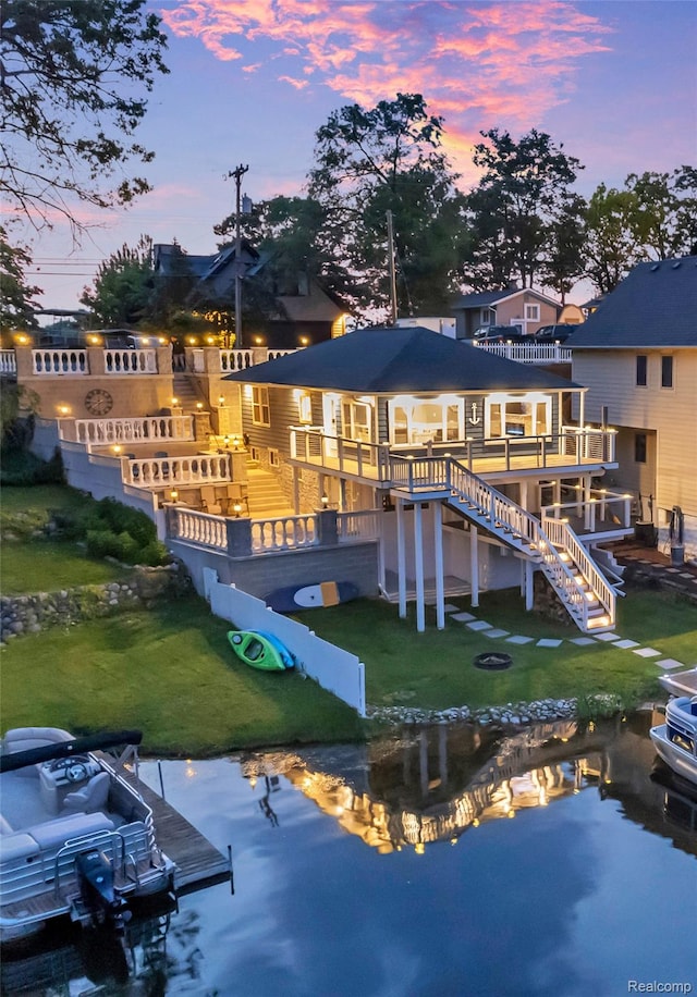 533 Bellevue Ave, Lake Orion, MI 48362 - back of property at dusk featuring a lawn, stairway, and a deck