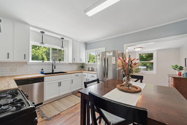 229 Water St, Grass Lake, MI 49240 - kitchen featuring wood counters, a sink, appliances with stainless steel finishes, light wood-type flooring, and decorative backsplash
