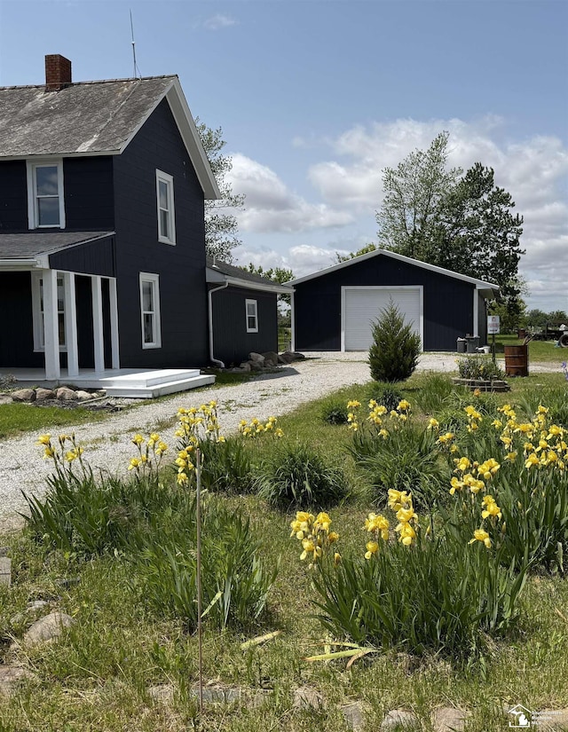 18200 Sherman, Milan, MI 48160 - view of home's exterior featuring an outdoor structure, a detached garage, and a chimney