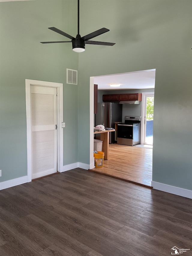 18200 Sherman, Milan, MI 48160 - unfurnished living room featuring wood finished floors, baseboards, a ceiling fan, and a towering ceiling