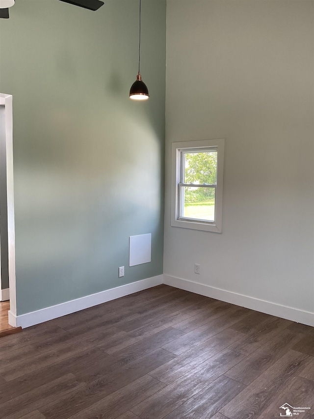 18200 Sherman, Milan, MI 48160 - unfurnished room featuring baseboards, dark wood-type flooring, and a towering ceiling