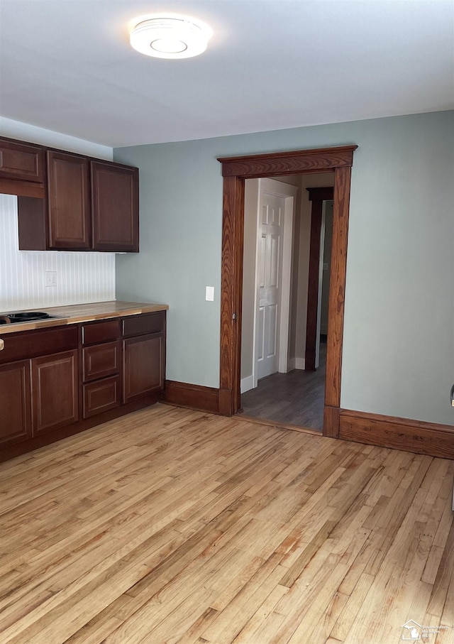 18200 Sherman, Milan, MI 48160 - kitchen with light wood finished floors, baseboards, dark brown cabinets, black electric cooktop, and light countertops