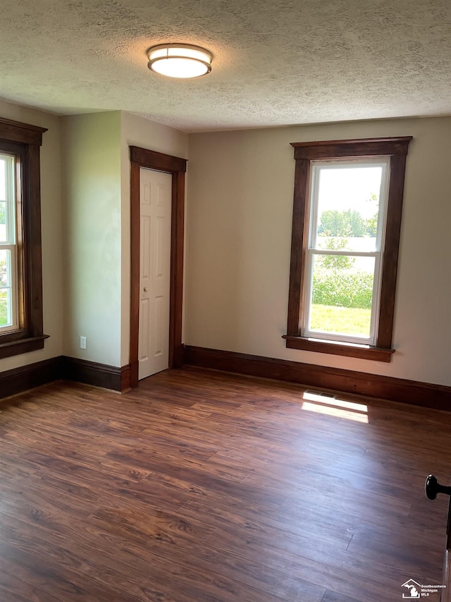 18200 Sherman, Milan, MI 48160 - unfurnished room with dark wood finished floors, a textured ceiling, and baseboards