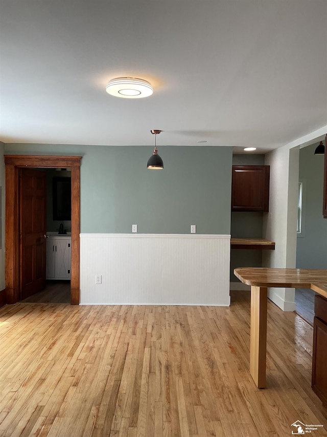 18200 Sherman, Milan, MI 48160 - unfurnished living room with light wood finished floors and a wainscoted wall