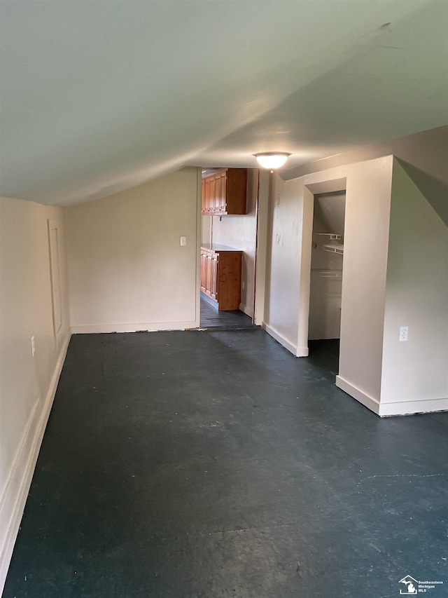 18200 Sherman, Milan, MI 48160 - unfurnished living room featuring concrete floors, baseboards, and vaulted ceiling