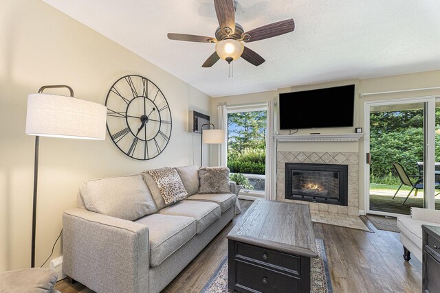 5737 Hilltop Way, Williamsburg, MI 49690 - living area with healthy amount of natural light, dark wood-type flooring, a tiled fireplace, and ceiling fan