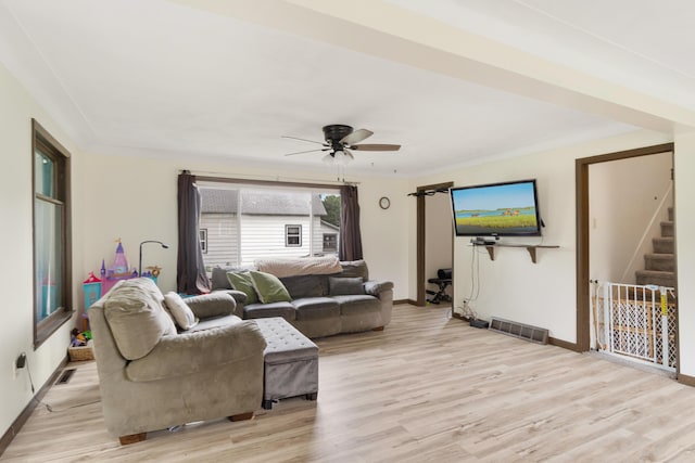 111 Greenleaf St, Onsted, MI 49265 - living room featuring light wood finished floors, a ceiling fan, baseboards, and stairs