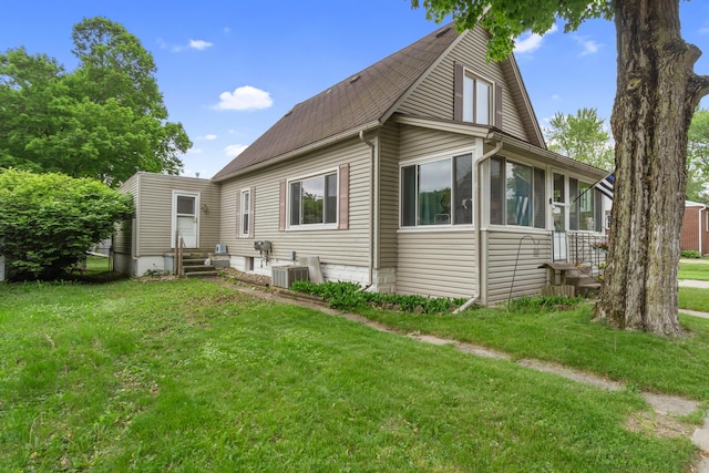 111 Greenleaf St, Onsted, MI 49265 - back of property featuring entry steps, a lawn, roof with shingles, and central AC