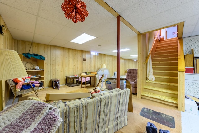 8279 Luce St, Alanson, MI 49706 - living room with a drop ceiling, wooden walls, carpet floors, and stairway