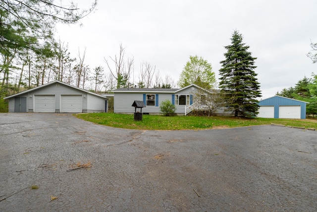8279 Luce St, Alanson, MI 49706 - view of front of house featuring a detached garage, an outbuilding, and a front lawn