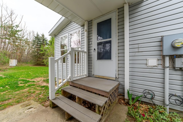 8279 Luce St, Alanson, MI 49706 - view of exterior entry with a lawn