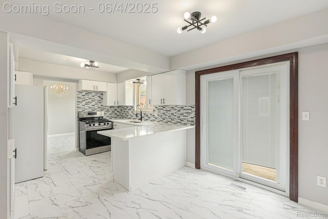 4325 Fox Hill Dr, Sterling Heights, MI 48310 - kitchen with a chandelier, stainless steel gas stove, freestanding refrigerator, and light marble finish floors