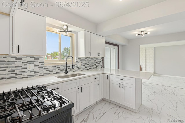 4325 Fox Hill Dr, Sterling Heights, MI 48310 - kitchen with a sink, a peninsula, white cabinetry, gas stove, and light marble finish flooring