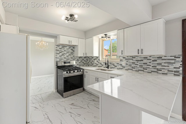 4325 Fox Hill Dr, Sterling Heights, MI 48310 - kitchen with stainless steel gas range, a sink, freestanding refrigerator, a chandelier, and light marble finish floors