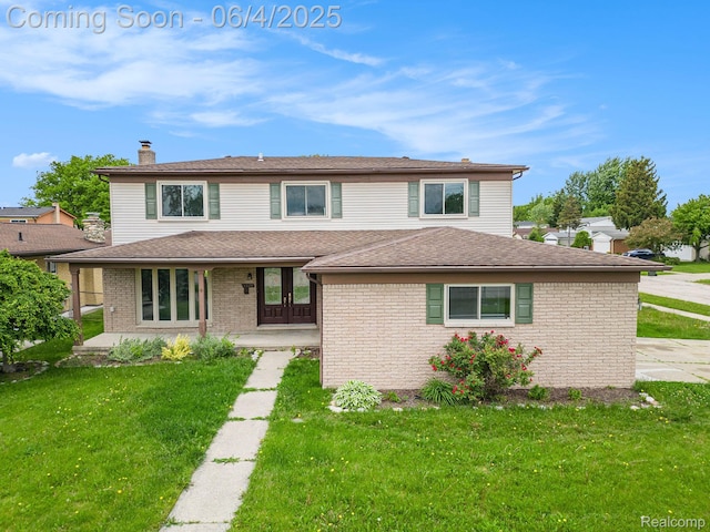 4325 Fox Hill Dr, Sterling Heights, MI 48310 - view of front facade featuring brick siding, a front yard, a chimney, and french doors