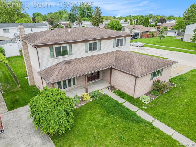 4325 Fox Hill Dr, Sterling Heights, MI 48310 - traditional-style house featuring a residential view, a shingled roof, a patio, and brick siding