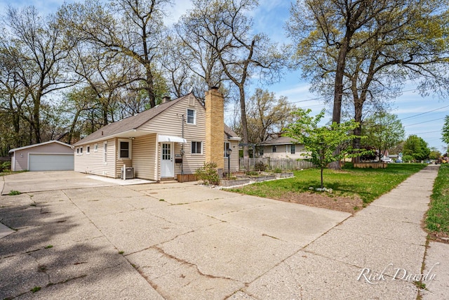 4015 Milan Ave SW, Wyoming, MI 49509 - view of front of property featuring an outdoor structure, a garage, and a chimney