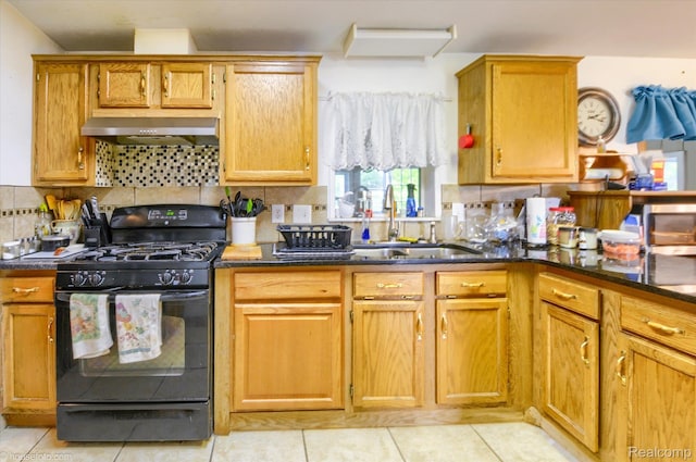 355 Carpenter Rd, Fostoria, MI 48435 - kitchen featuring black gas range, range hood, a sink, and light tile patterned floors