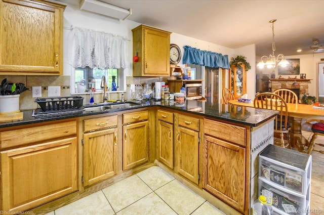 355 Carpenter Rd, Fostoria, MI 48435 - kitchen featuring a sink, backsplash, a chandelier, a peninsula, and light tile patterned floors
