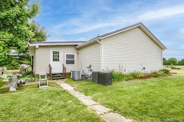 355 Carpenter Rd, Fostoria, MI 48435 - rear view of house with a yard, central AC unit, and entry steps