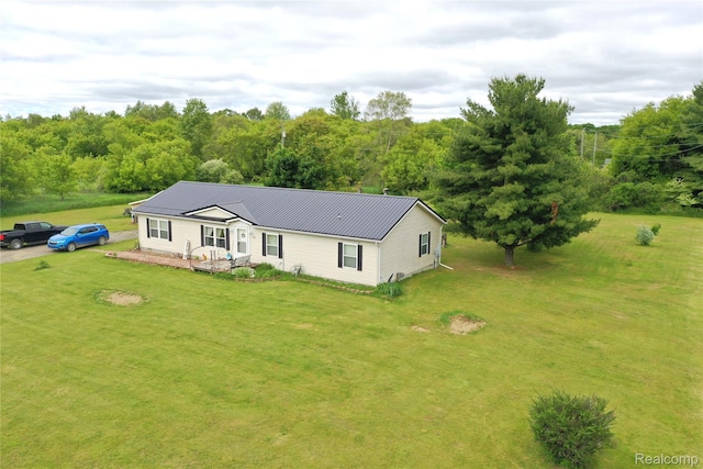 355 Carpenter Rd, Fostoria, MI 48435 - manufactured / mobile home featuring metal roof, a front yard, and a forest view