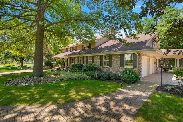 6130 Eidson Rd, Saint Joseph, MI 49085 - view of front of home with an attached garage, a front yard, driveway, stone siding, and roof with shingles