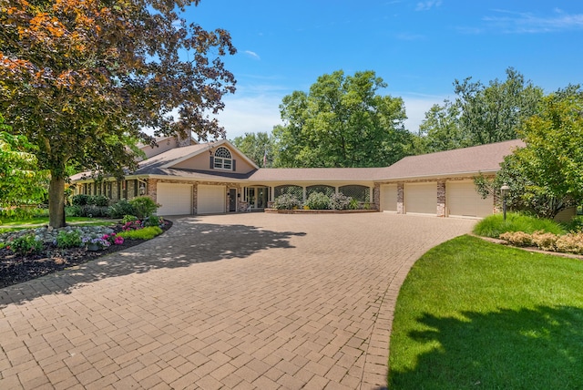 6130 Eidson Rd, Saint Joseph, MI 49085 - view of front of home with an attached garage, decorative driveway, and a front yard