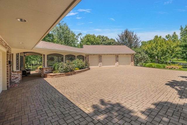 6130 Eidson Rd, Saint Joseph, MI 49085 - view of patio with an attached garage and decorative driveway