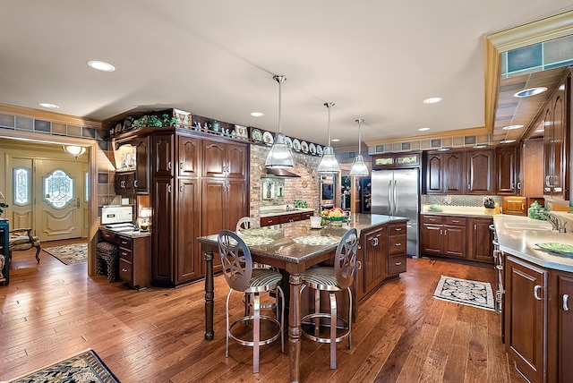 6130 Eidson Rd, Saint Joseph, MI 49085 - kitchen featuring stainless steel fridge, a kitchen island, hardwood / wood-style flooring, crown molding, and dark brown cabinets