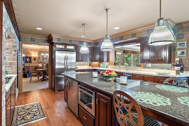 6130 Eidson Rd, Saint Joseph, MI 49085 - kitchen featuring stainless steel appliances, light wood finished floors, ornamental molding, backsplash, and pendant lighting