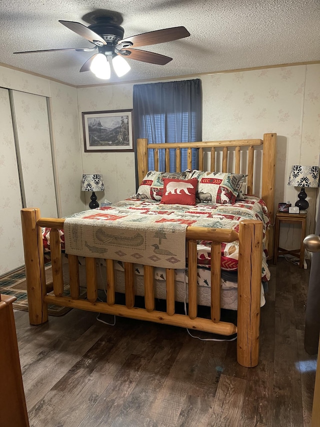 11064 S Hulbert Rd, Hulbert, MI 49748 - bedroom with hardwood / wood-style flooring, a textured ceiling, wallpapered walls, and a ceiling fan